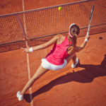Female tennis player hitting a ball with forehand volley