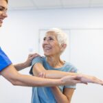 Woman receiving assistance from a physical therapist for shoulder tendonitis