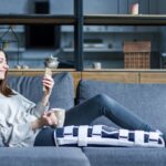 A woman resting on the couch with knee brace on recovering from a car accident