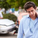 A young man grabbing his neck in pain after a car accident.