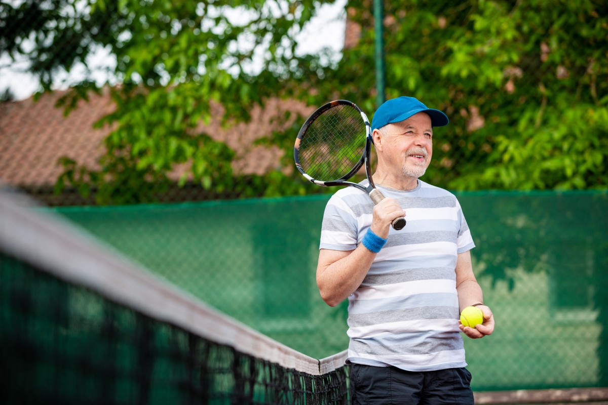 Older man returning to tennis after a successful reverse shoulder replacement surgery.